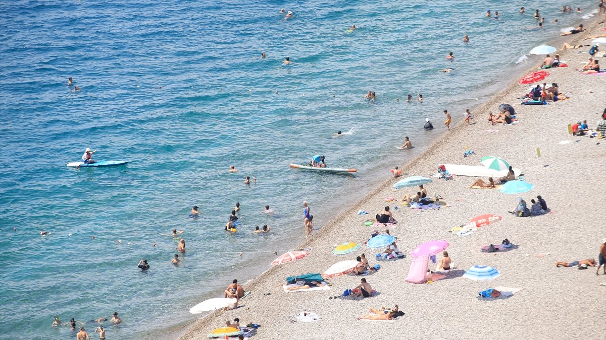 Antalya'da sıcaktan bunalan turistler sahilleri doldurdu