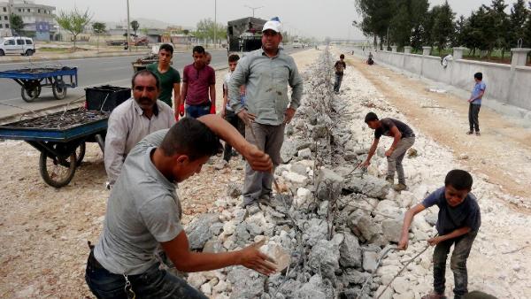 Yıkılan duvarın demirlerini çocuklar topladı