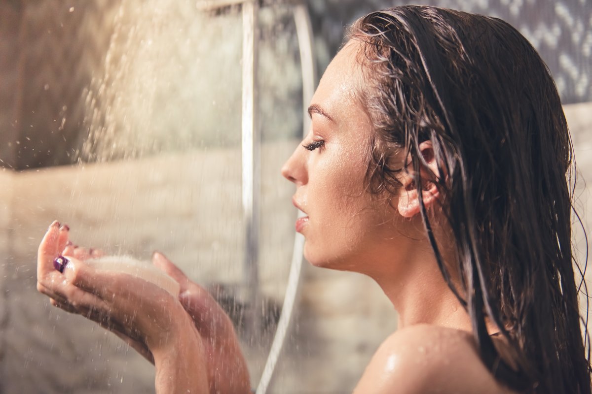 Красивая голая девушка принимает душ в номере отеля