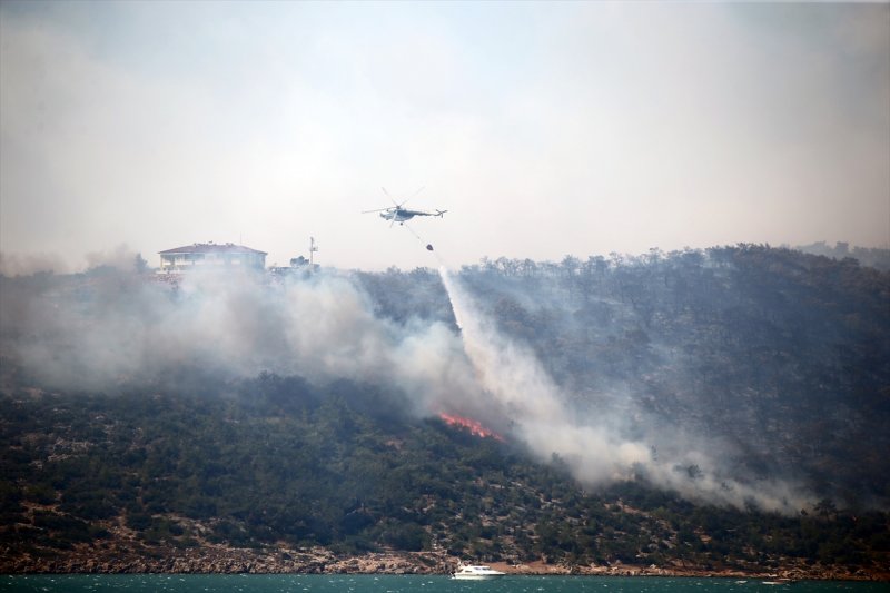 Aladağ Boztahta Mahallesi'ndeki ormanlık alandaki yangın için de çok sayıda arazöz, iş makinesi ve yer ekibi görev alıyor.