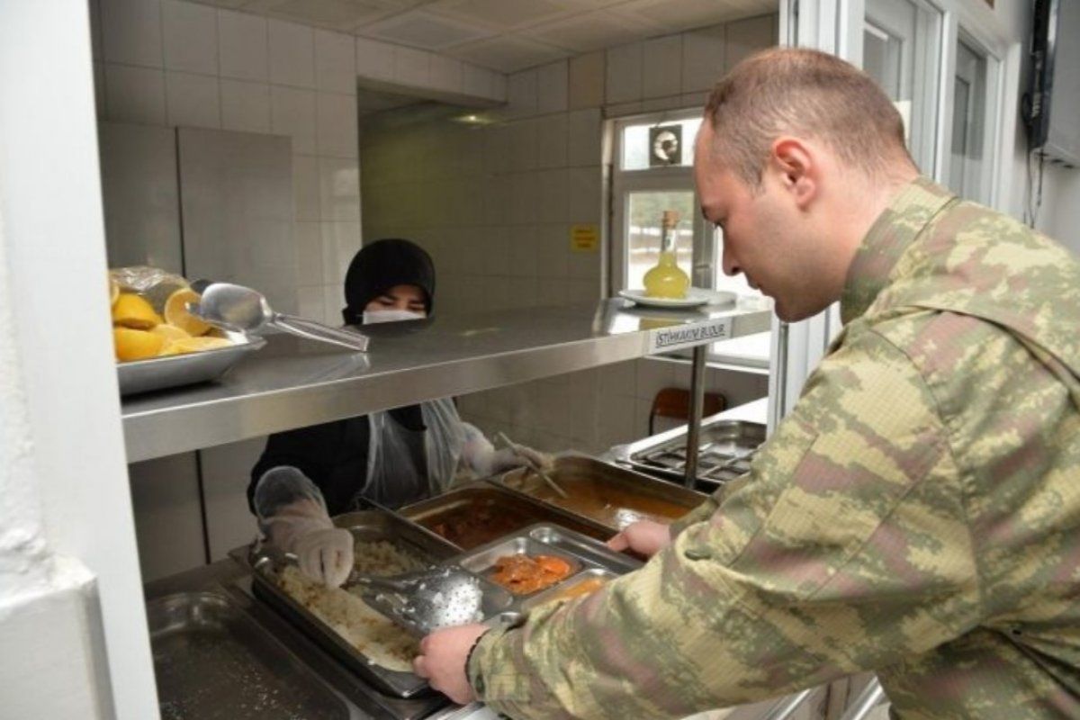 Askerler aralıklı düzende oturup, virüsten korunuyor