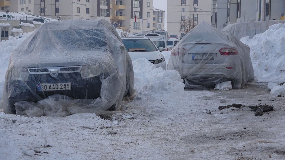 Yüksekova’da buz tutan araçları naylonla kapladılar