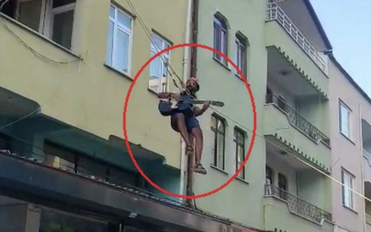 Bursa'da eşyalarını taşıdığı halatın üzerinde gitar çalıp, şarkı söyledi