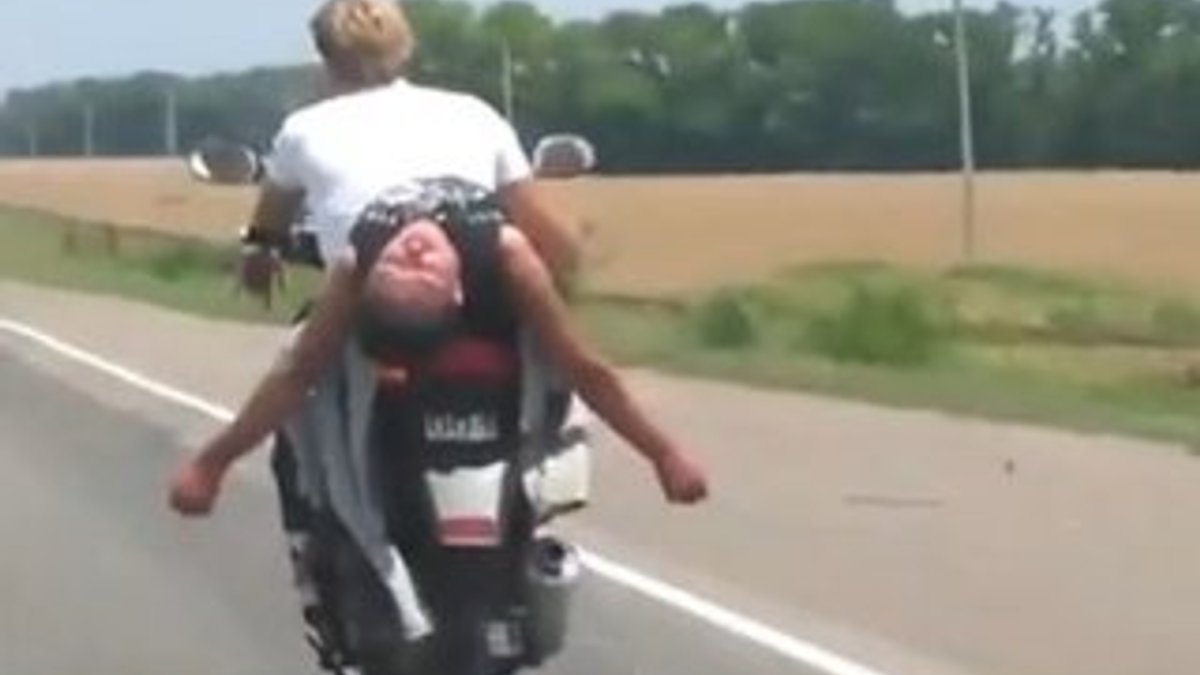 Sarhoş arkadaşını motorunda baş aşağı taşıdı