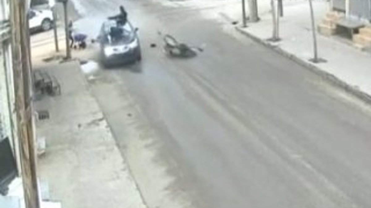 Motosiklet sürücüsü çarptığı otomobilin üstünde kaldı