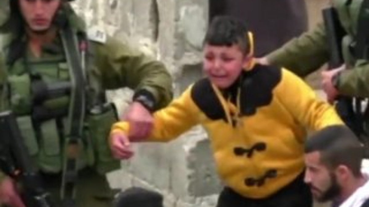İsrail askeri Filistinli çocuğu yalın ayak sürükledi İZLE