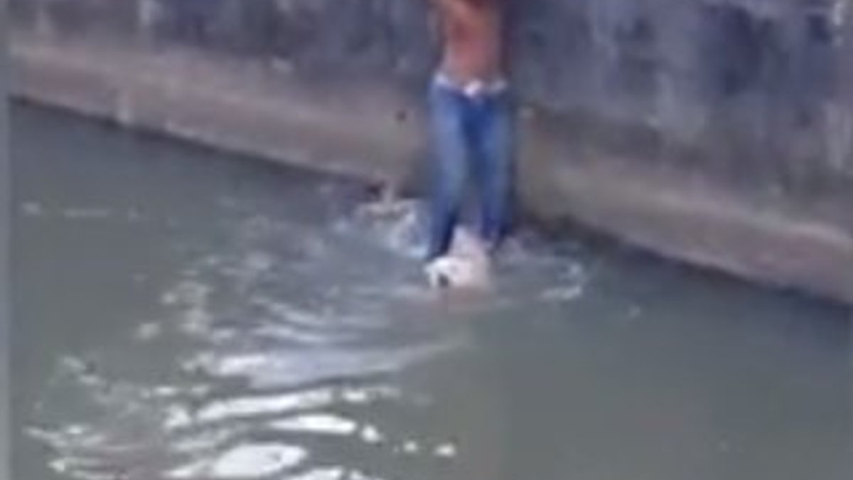 Su kanalına düşen köpeği ayaklarıyla kurtardı