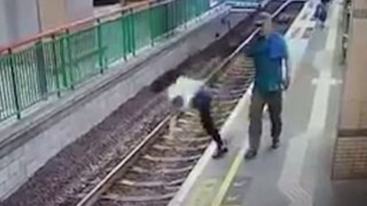 Çin'de bir adam güvenlik görevlisini raylara itti