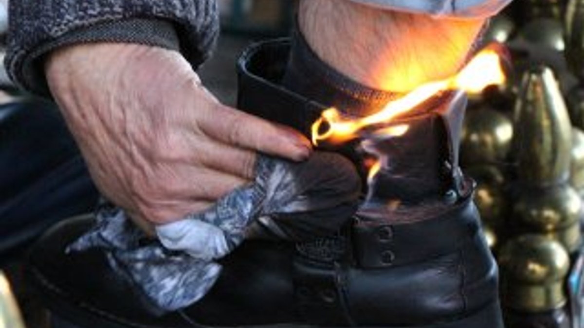 Amasyalı adam ayakkabıları ateşle boyuyor