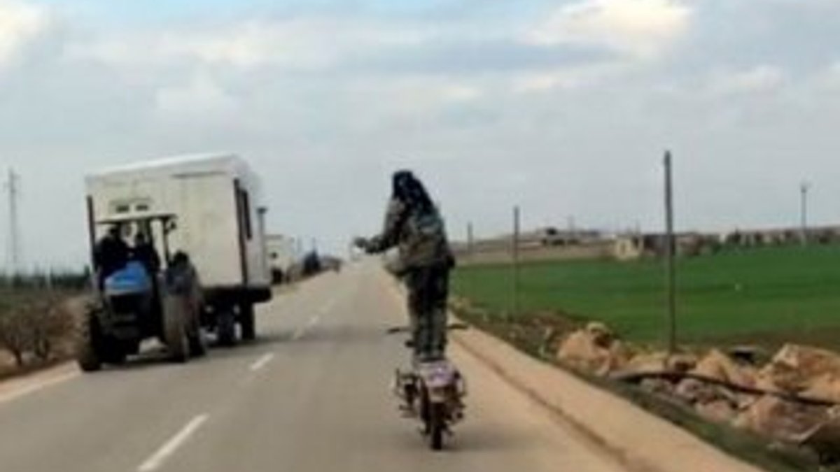 Ayakta motosiklet kullanan Suriyeli