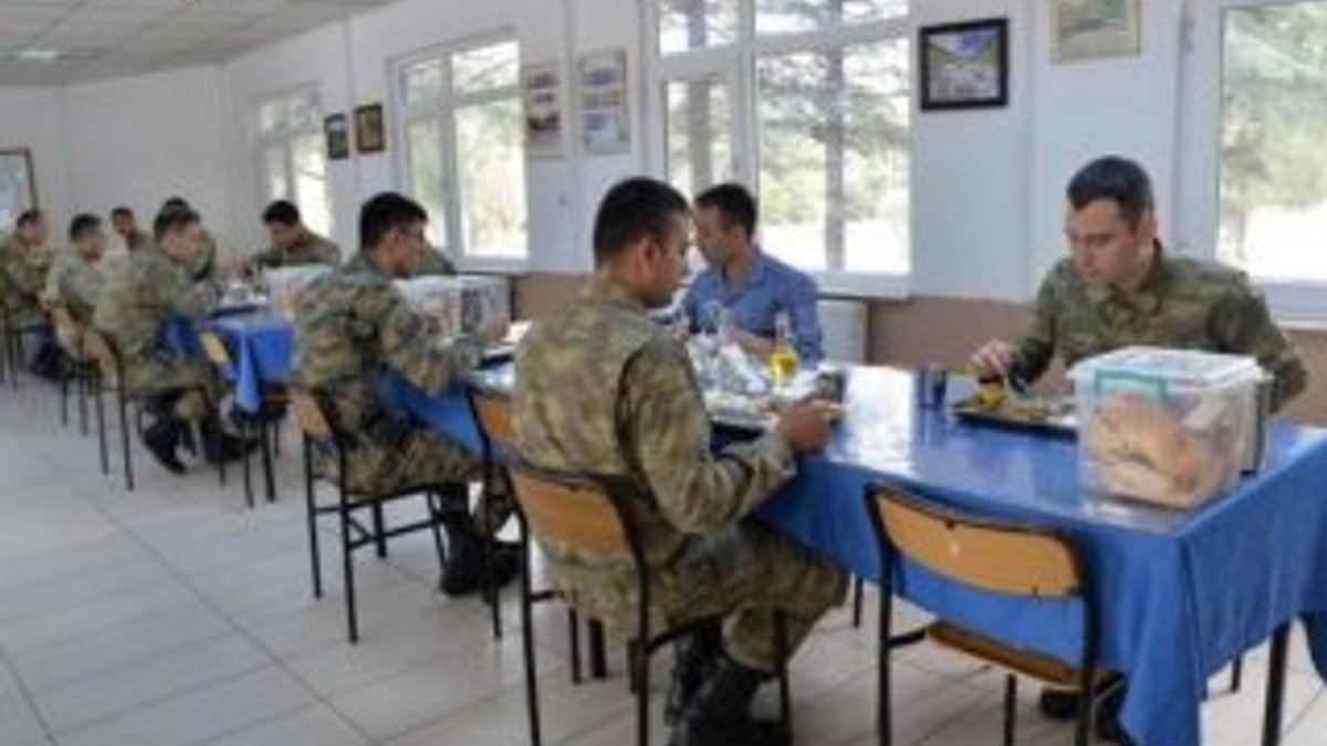 Askerler aralıklı düzende oturup, virüsten korunuyor