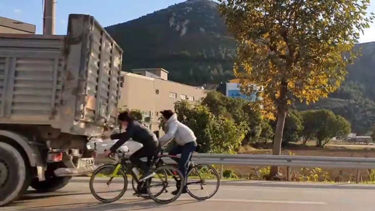 Bursa'da bisikletli gençler, yine tıra tutunarak trafiği tehlikeye attı