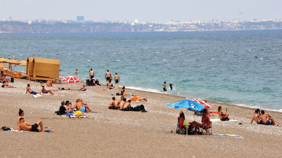 Antalya’da turistler, bulutlu havaya rağmen denize girdi