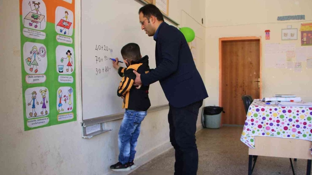 Elazığ'daki fedakar öğretmen, engelli öğrencisine yardım ediyor