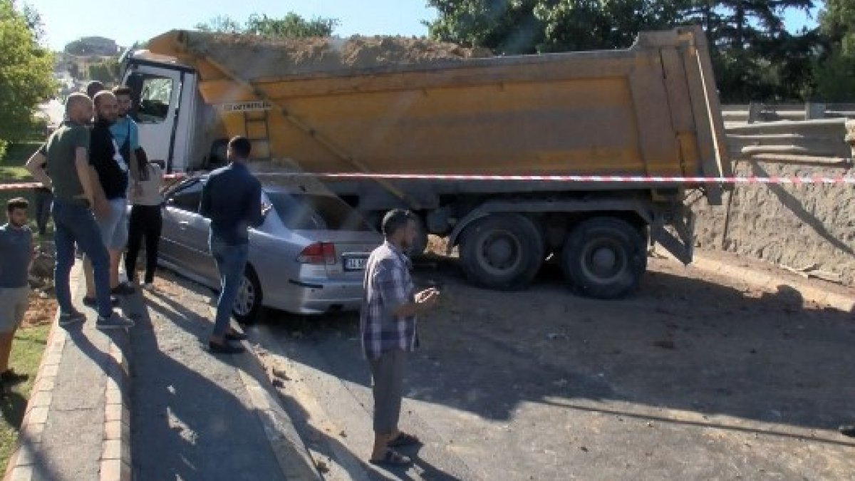 İstanbul'da virajı alamayan hafriyat kamyonu otomobilin üzerine düştü