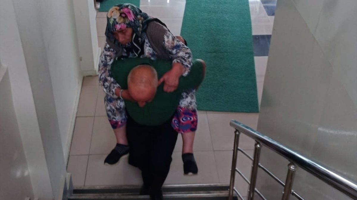 Bayburt'ta nüfus müdürlüğü memuru, yaşlı kadını sırtında üst kata taşıdı