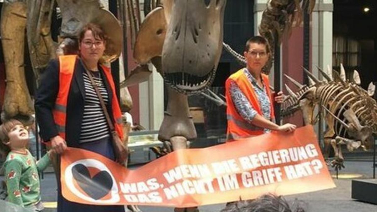Almanya'da iklim aktivistleri, kendilerini dinozor iskeletine yapıştırdı
