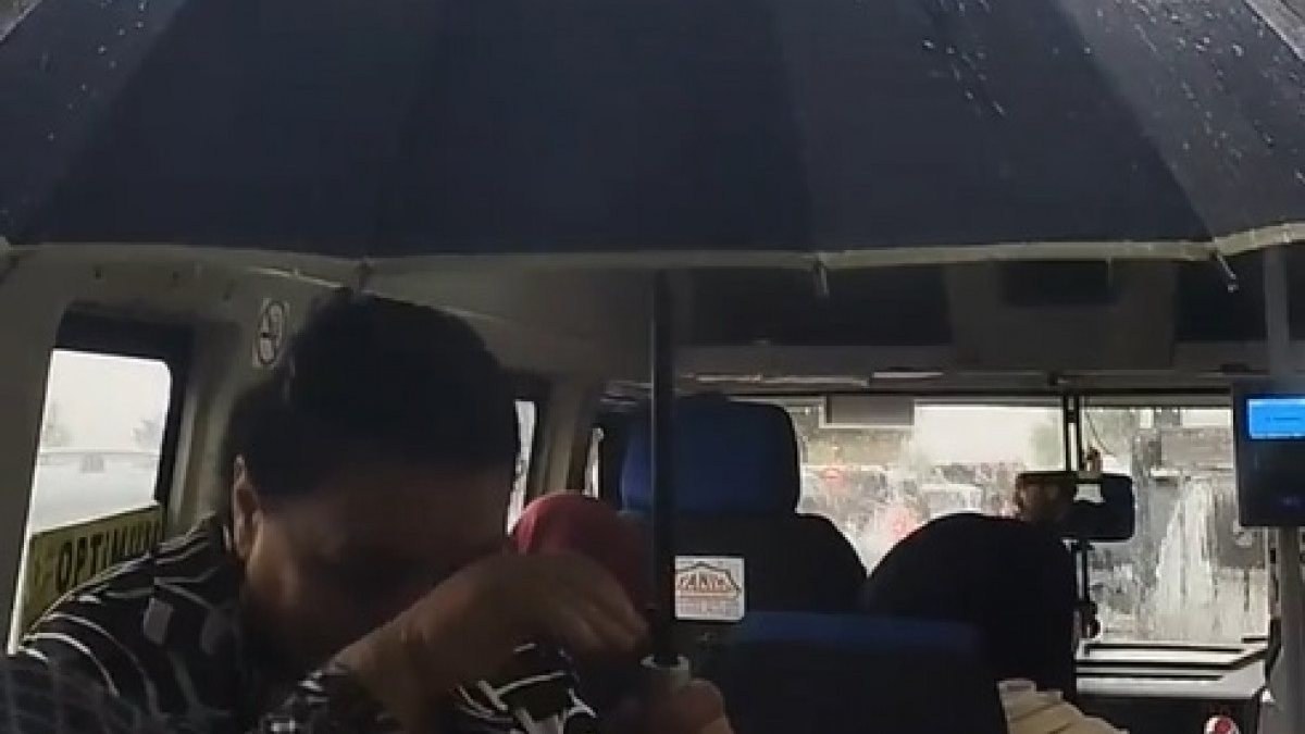 Adana'da dolmuşta yağmurdan etkilenen yolcu şemsiye açtı