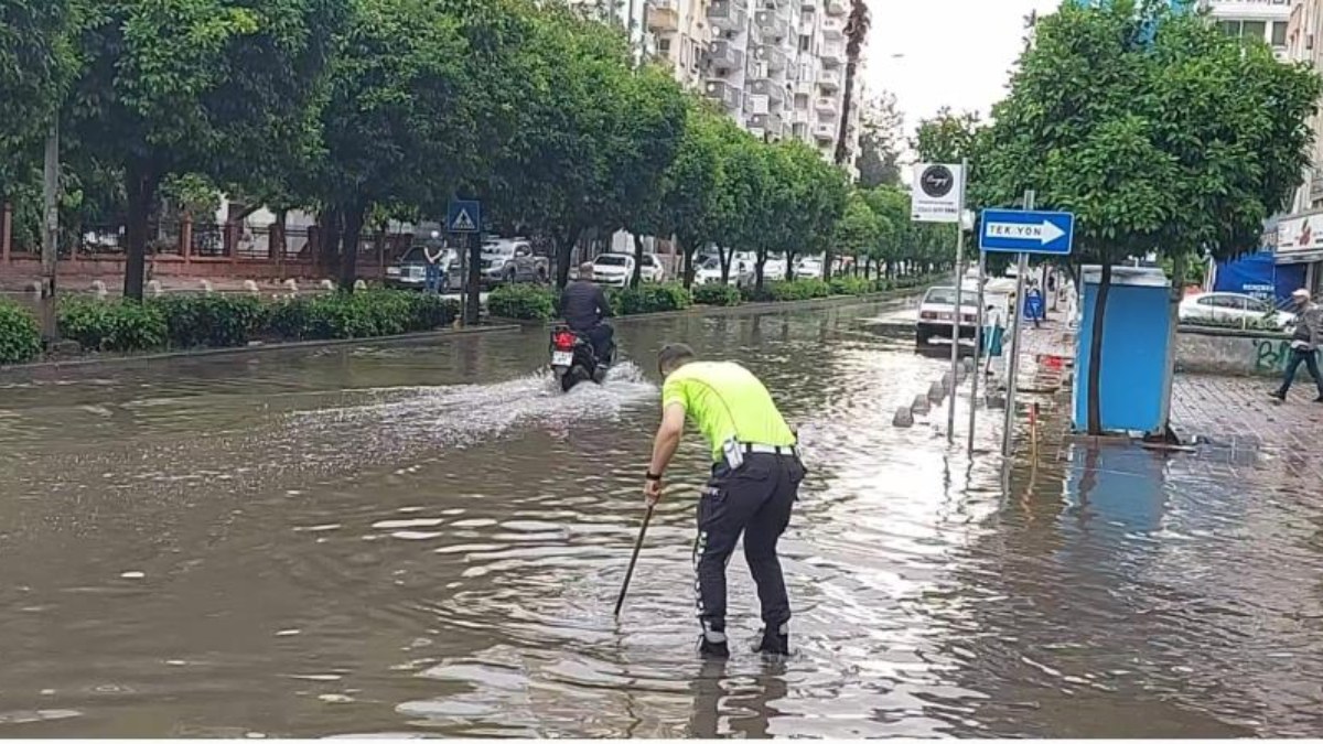 Adana'da polis, su dolu caddede tıkanan rögarı açtı