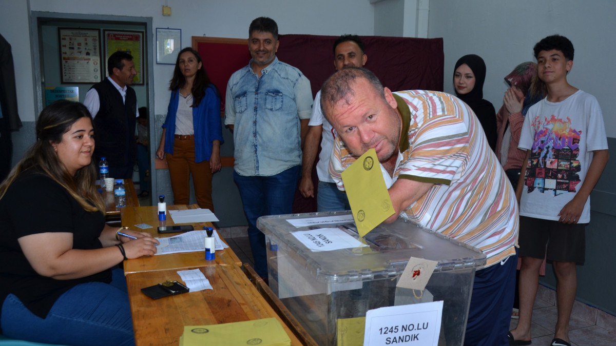 Antalya'da kolları olmayan engelli, oy zarfını ağzıyla sandığa attı