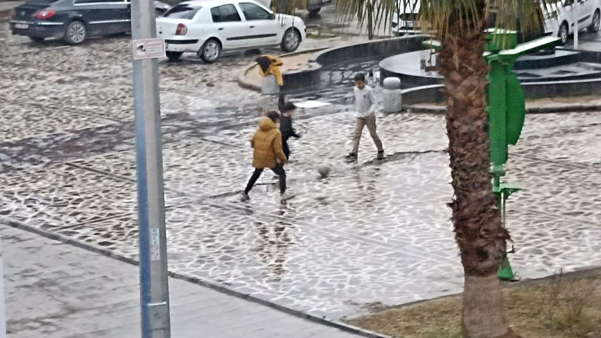 Mardin'deki çocuklar, yağmurla dolan meydanı temizleyip futbol oynadı