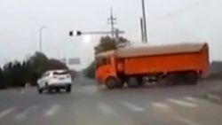 Çin'de kum taşıyan kamyon otomobilin üzerine devrildi