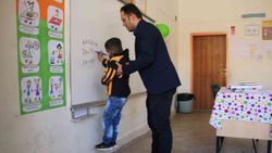 Elazığ'daki fedakar öğretmen, engelli öğrencisine yardım ediyor