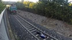 Raylara yatan gencin üzerinden tren geçti