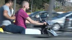 Hızla seyreden motosikletin arkasında dürüm yiyen genç İZLE