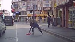 Caddeye düşen Türk bayrağını yerden aldı