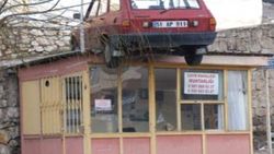 Niğde'de otomobil muhtarlığın çatısına uçtu