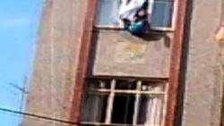 Yıkımı engellemek için çocuğunu camdan sarkıttı