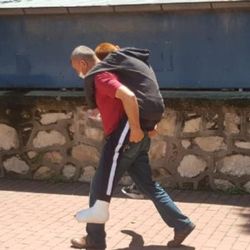 Bursa'da ayağı alçılı oğlunu okula sırtında taşıdı