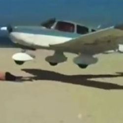 Uçak kumsalda güneşlenen adamın sırtına iniyordu İZLE