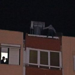 Binanın çatısından sarkan kadını cips yiyerek izlediler