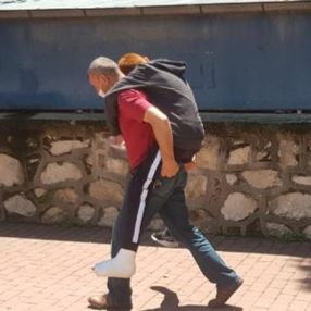 Bursa'da ayağı alçılı oğlunu okula sırtında taşıdı