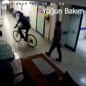 Hastane koridorunda bisiklet süren doktor