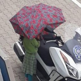 Polisin motosikleti ıslanmasın diye şemsiyesiyle bekledi