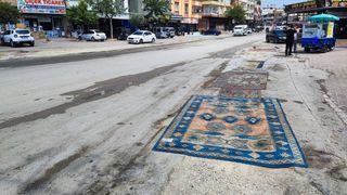 Adana'da asfaltı yapılmayan yola esnaftan çözüm: Halı serildi