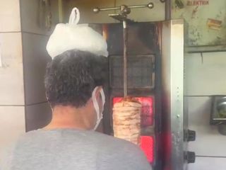 Hatay'da sıcaktan bunalan dönerci ustası kafasına buz torbası koydu