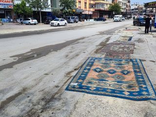 Adana'da asfaltı yapılmayan yola esnaftan çözüm: Halı serildi