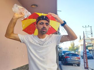 Adana'da aşırı sıcaklara ilginç çözüm: Kafasında şemsiyeyle geziyor