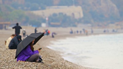 Antalya'da yağmura rağmen şemsiye altında deniz keyfi