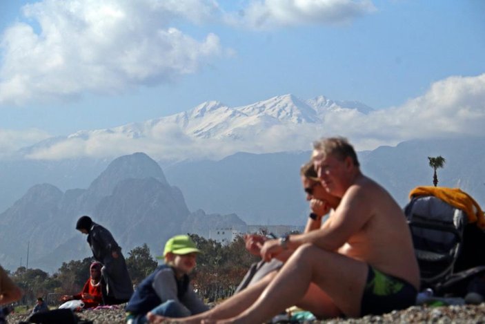 Antalya’da zirve beyaza bürünürken sahilde denize girdiler