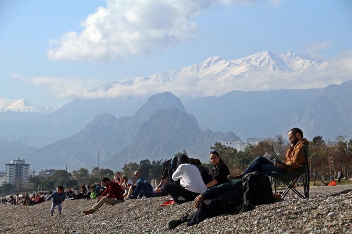 Antalya’da zirve beyaza bürünürken sahilde denize girdiler