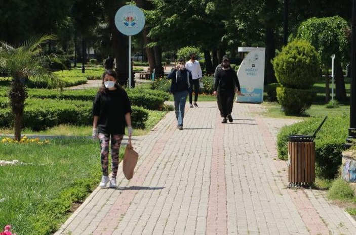 Adana'da, parkta oturan çift sosyal mesafeyi önemsemedi