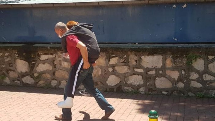 Bursa'da ayağı alçılı oğlunu okula sırtında taşıdı