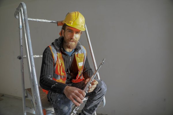 a Yan flüt çalan inşaat işçisi