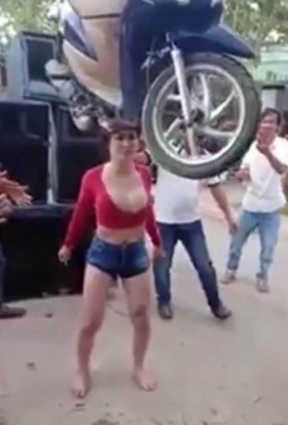 Asyalı genç kadın kafasında scooter taşıdı