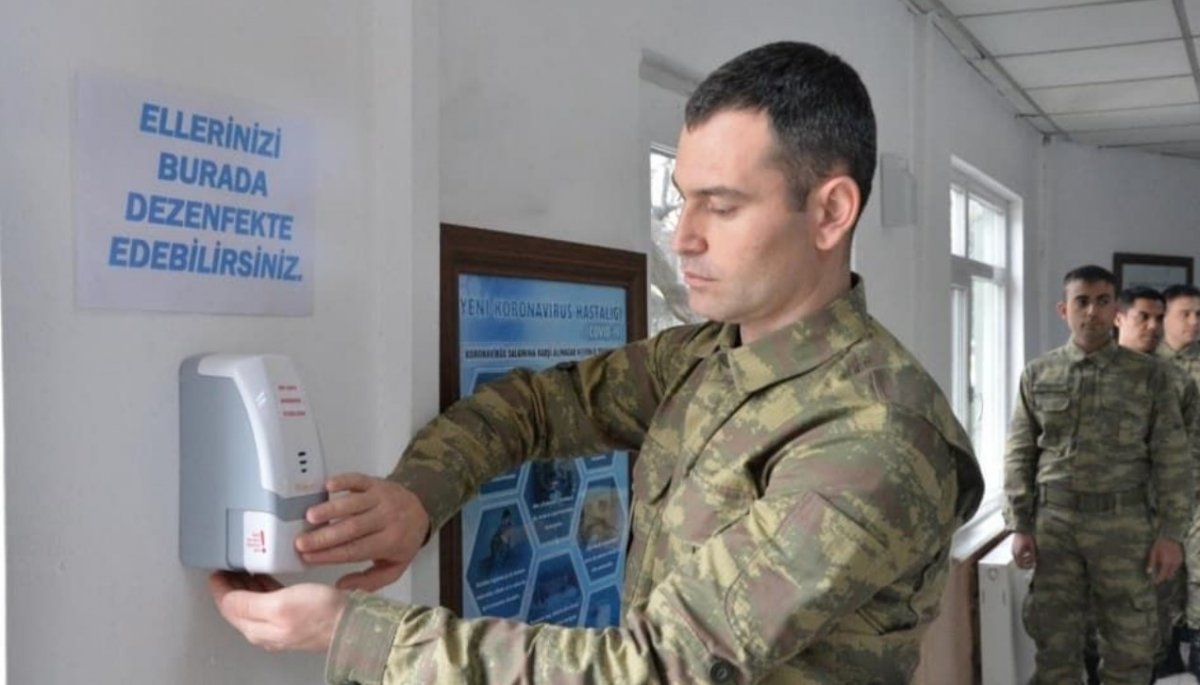 Askerler aralıklı düzende oturup, virüsten korunuyor